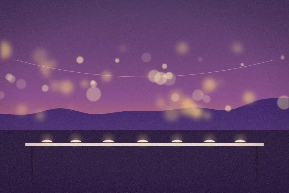 Illustration of a long dinner table beneath glowing string lights at twilight